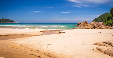 Praia dos Antigos, com areia clara e pedras no canto
